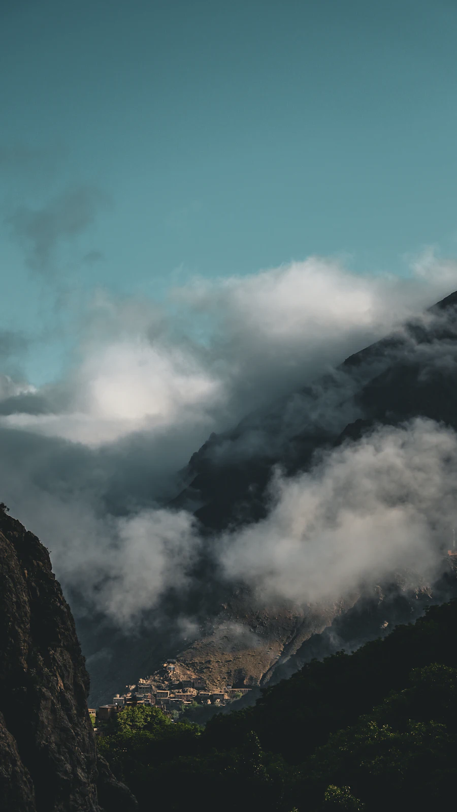 High Atlas Mountains village under cloudy peaks in Morocco