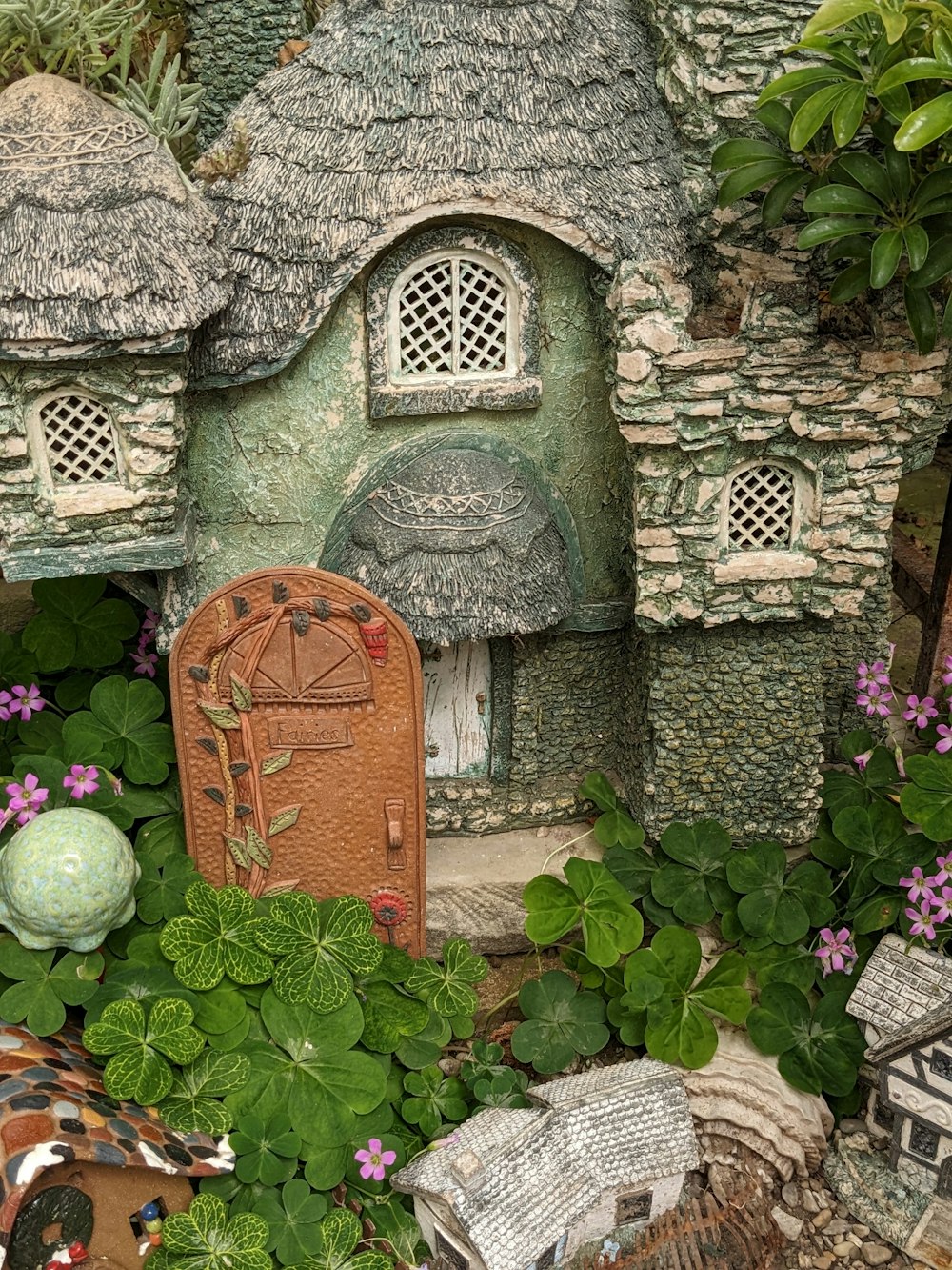 Un jardín de hadas con una casa de hadas y artículos de jardín