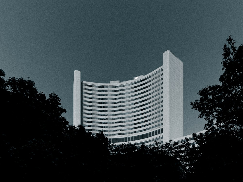 a tall white building with trees in front of it