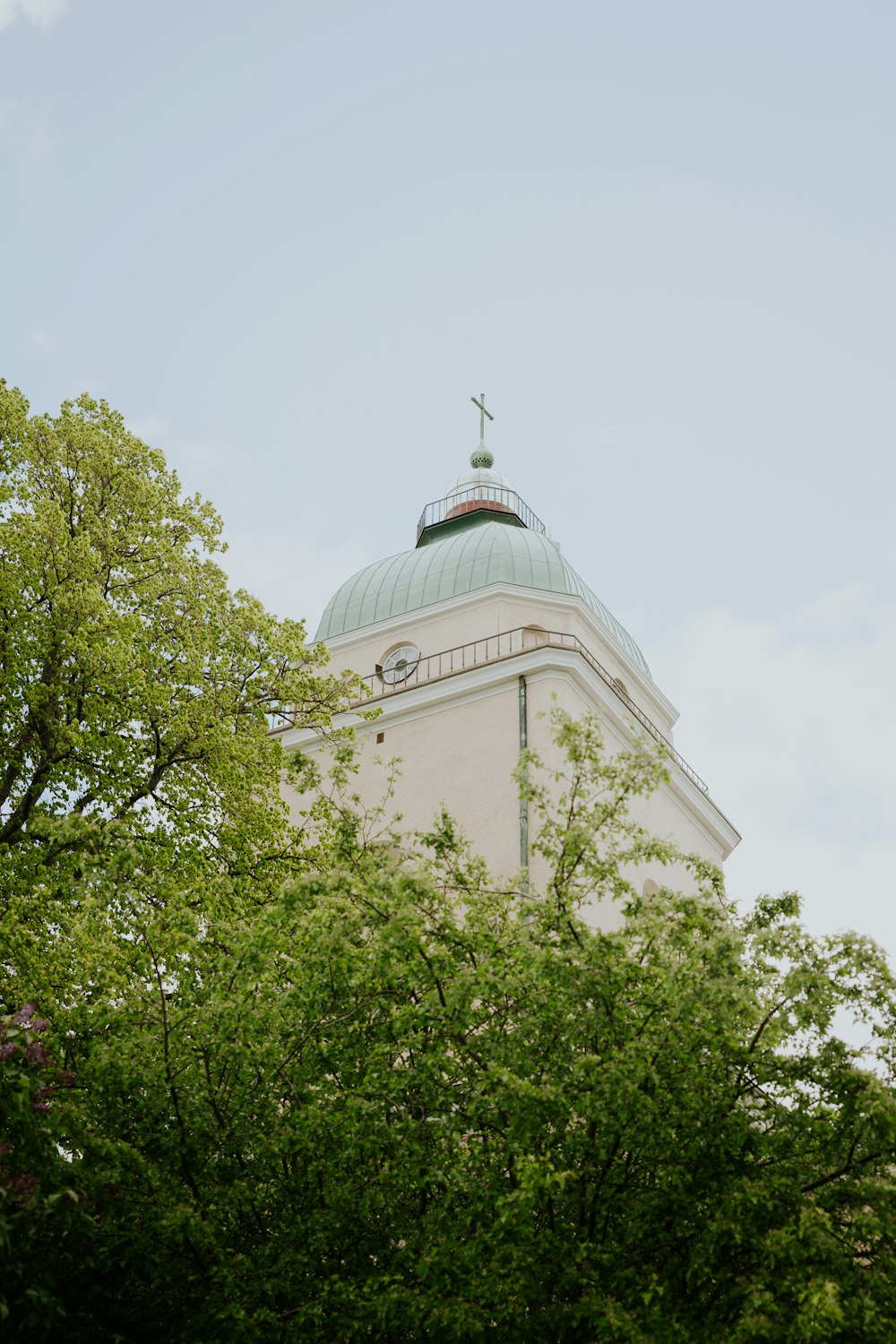 a tall white building with a cross on top of it