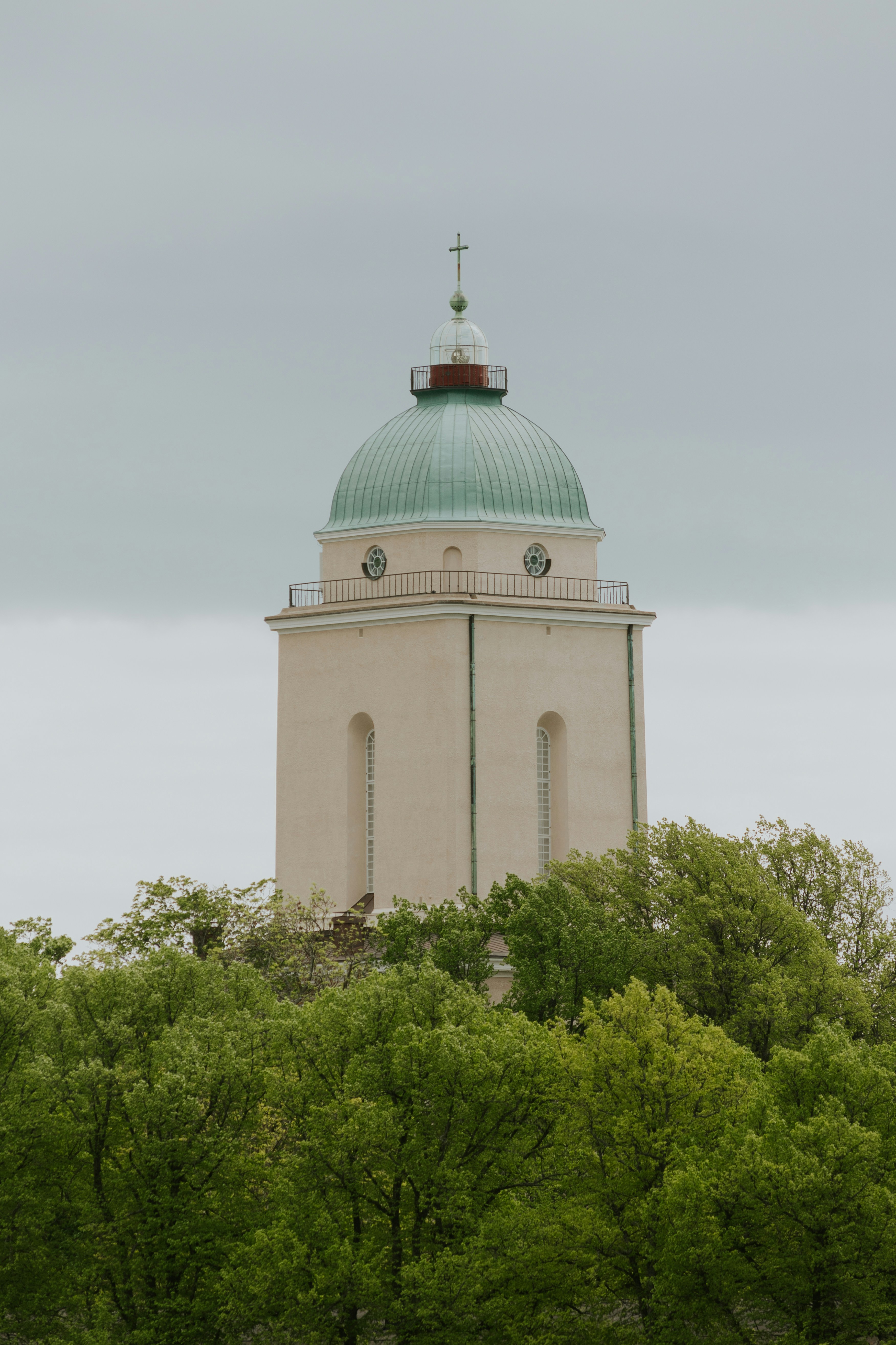 a white building with a green dome on top of a hill