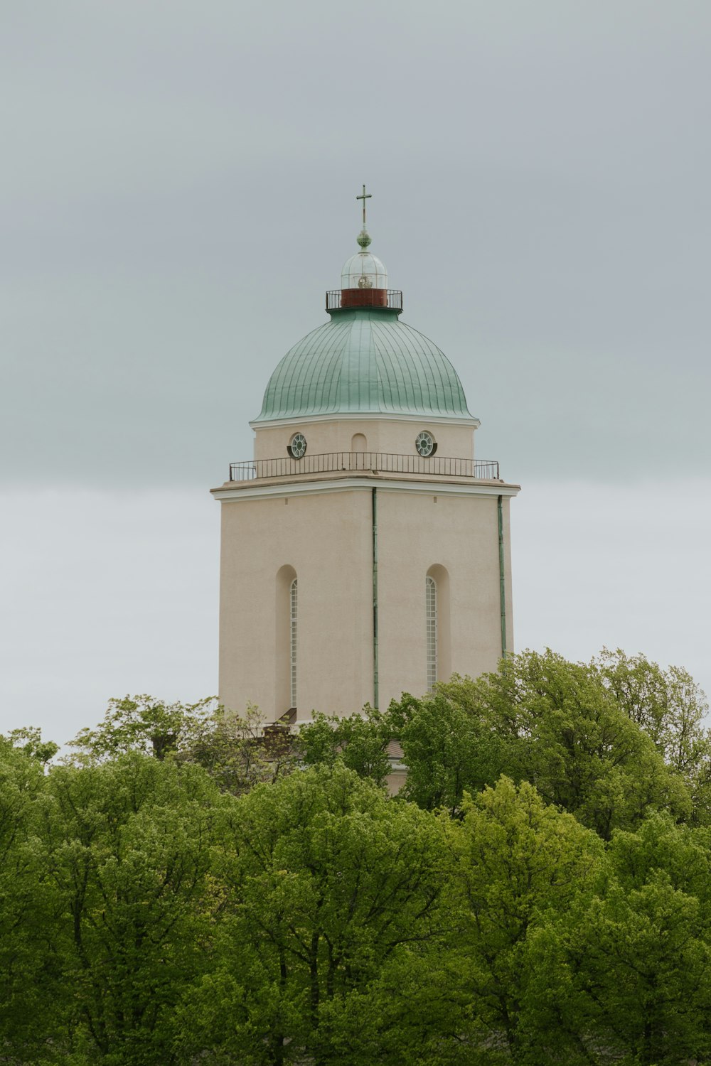 a white building with a green dome on top of a hill