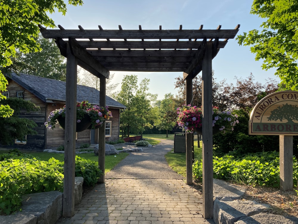 a walkway with a sign and flowers on it