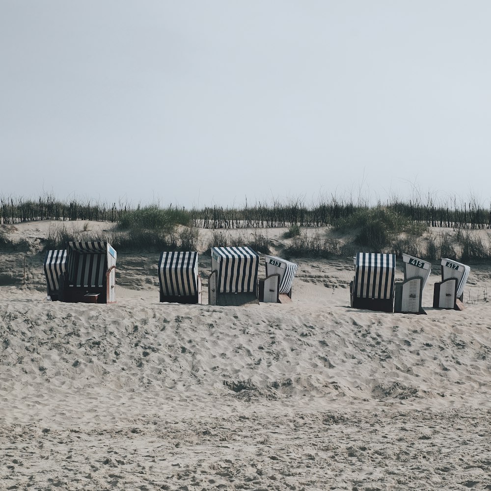 a row of beach chairs sitting on top of a sandy beach