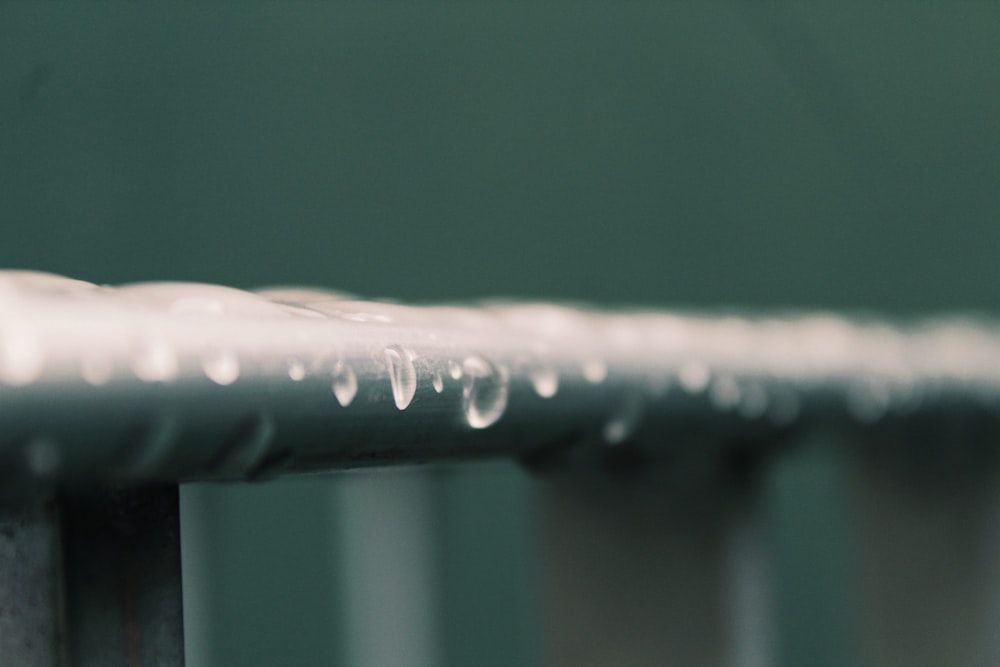 a close up of a metal rail with water droplets on it