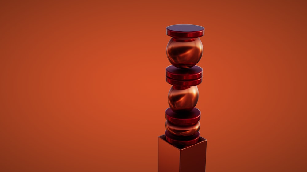 a tall red vase sitting on top of a wooden stand