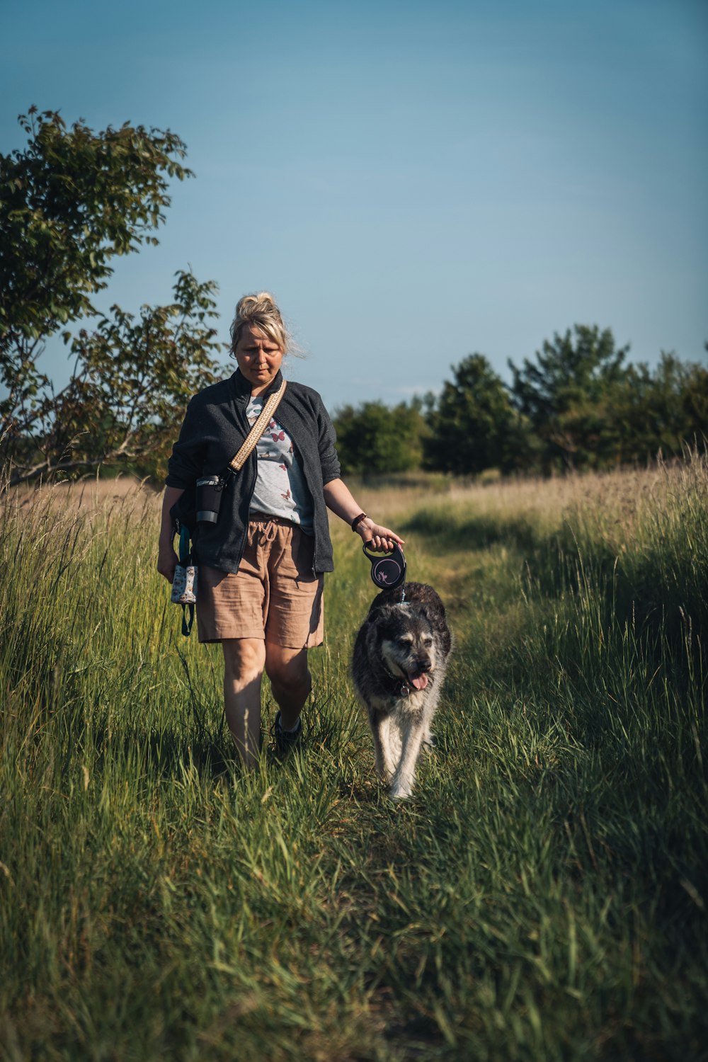 a woman walking her dog on a trail