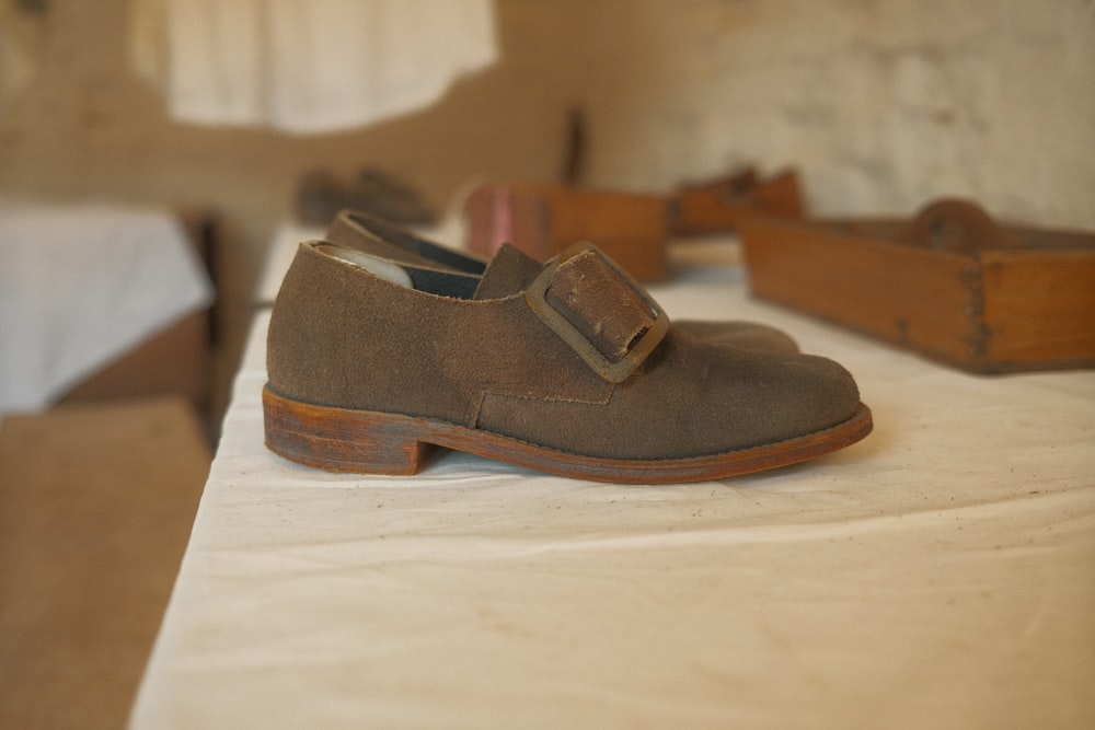 a pair of brown shoes sitting on top of a table