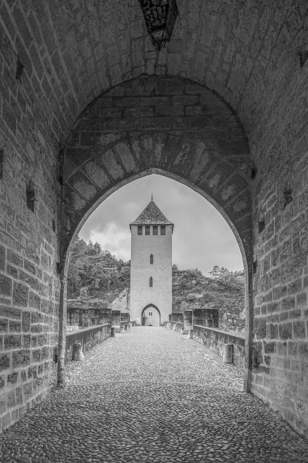 a black and white photo of a stone bridge