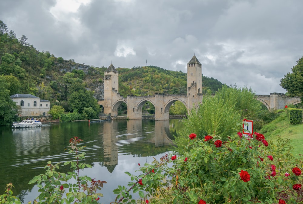 a bridge over a body of water with a castle in the background