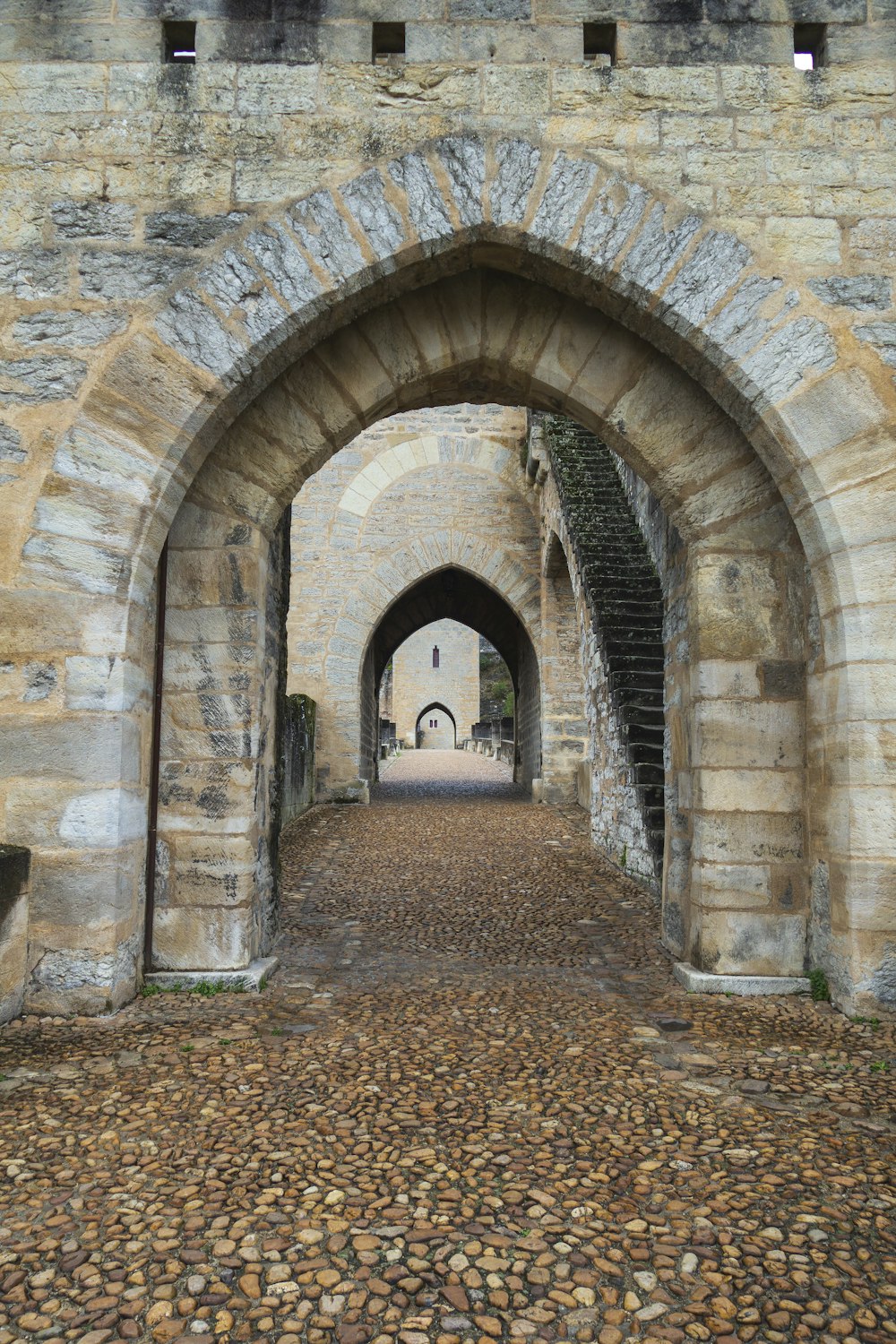 a stone archway with a clock on the side of it
