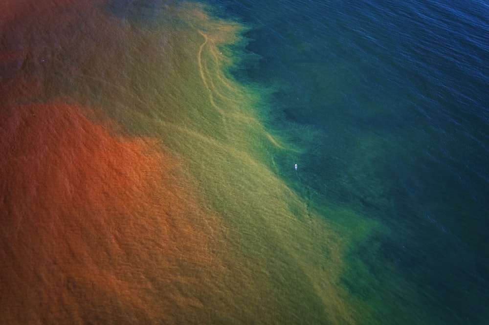 a body of water that has some green and orange dye on it