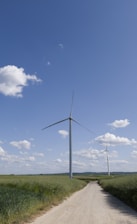a dirt road leading to a wind farm
