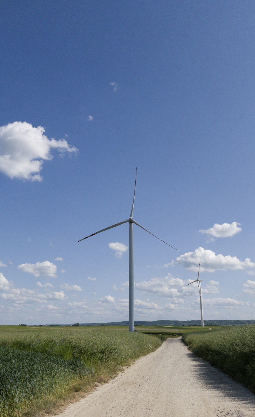 a dirt road leading to a wind farm