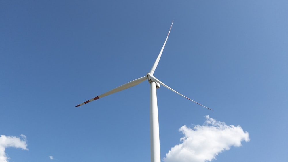 a wind turbine in the middle of a blue sky