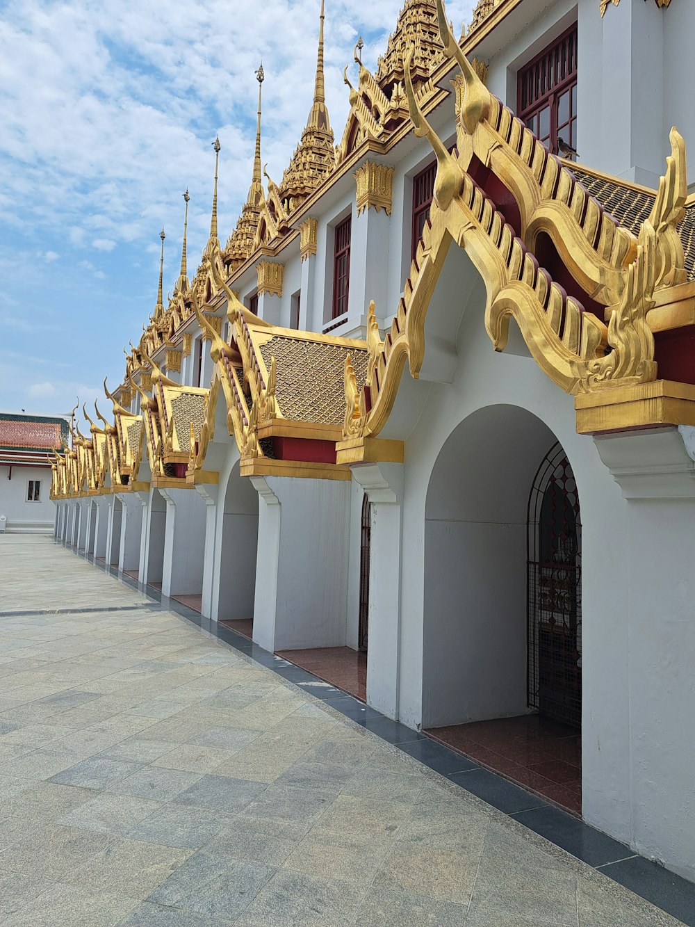 a row of white buildings with gold roof tops