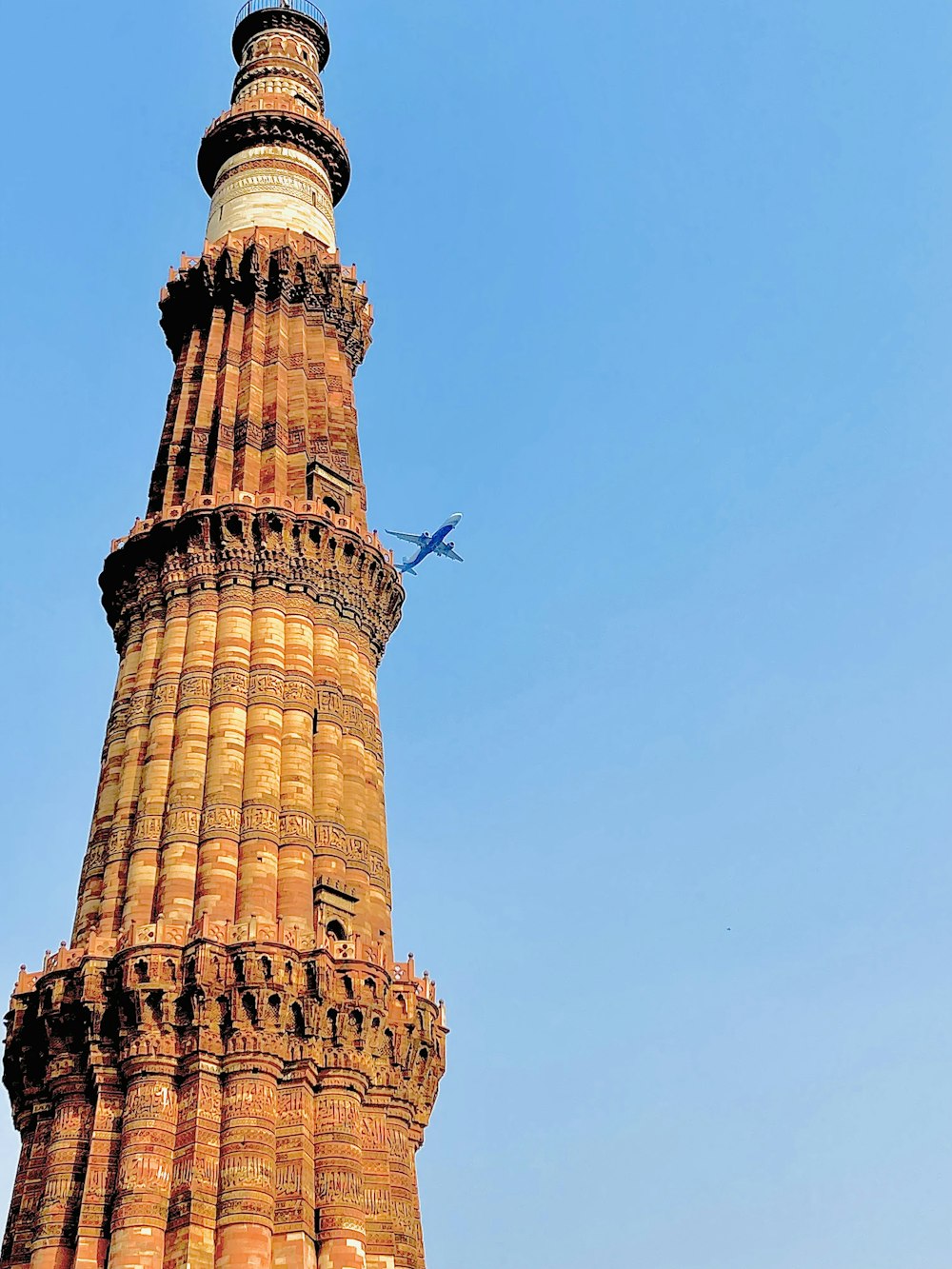 an airplane is flying over a tall tower