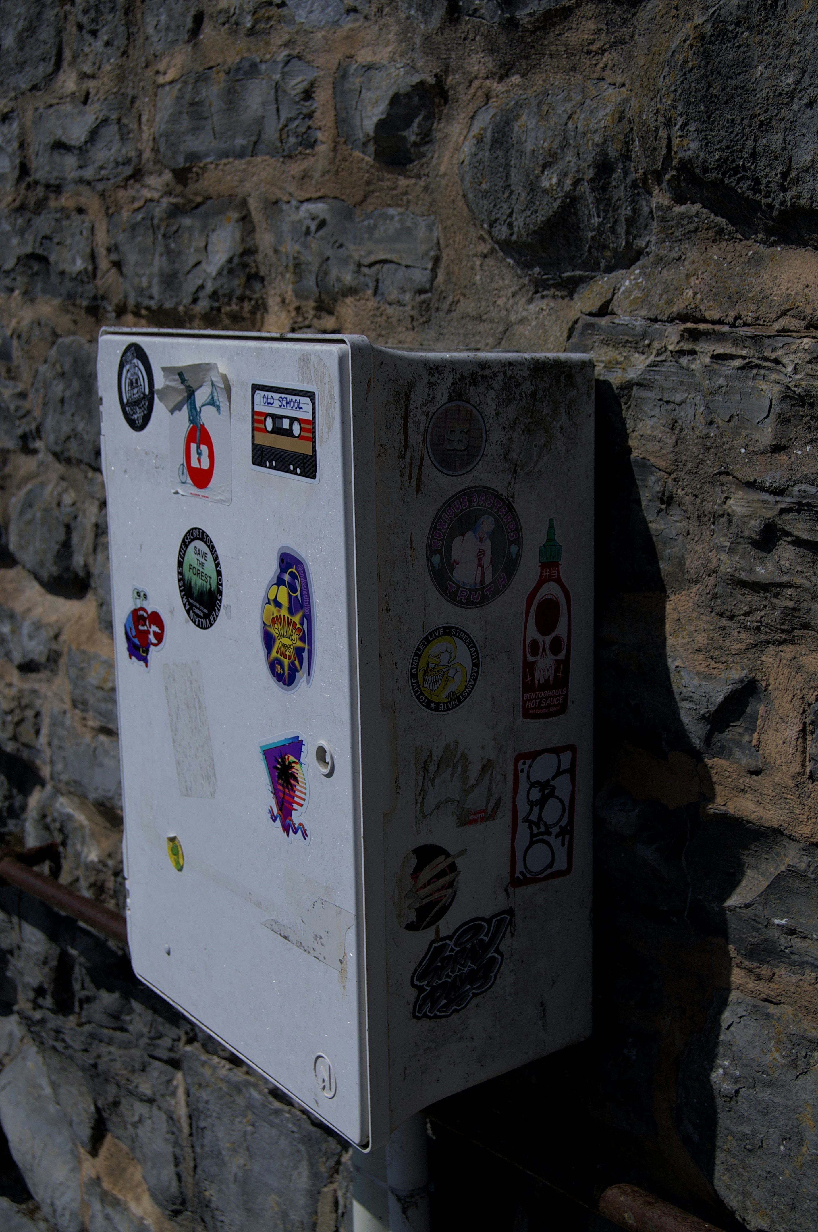 a white refrigerator sitting next to a stone wall