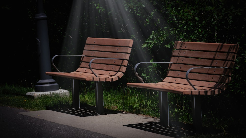 two wooden benches sitting next to each other on a sidewalk