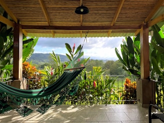 a hammock on a porch with a view of the mountains