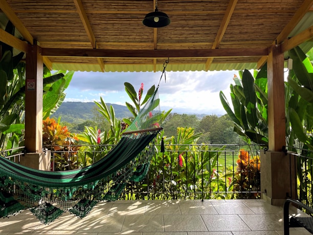 a hammock on a porch with a view of the mountains