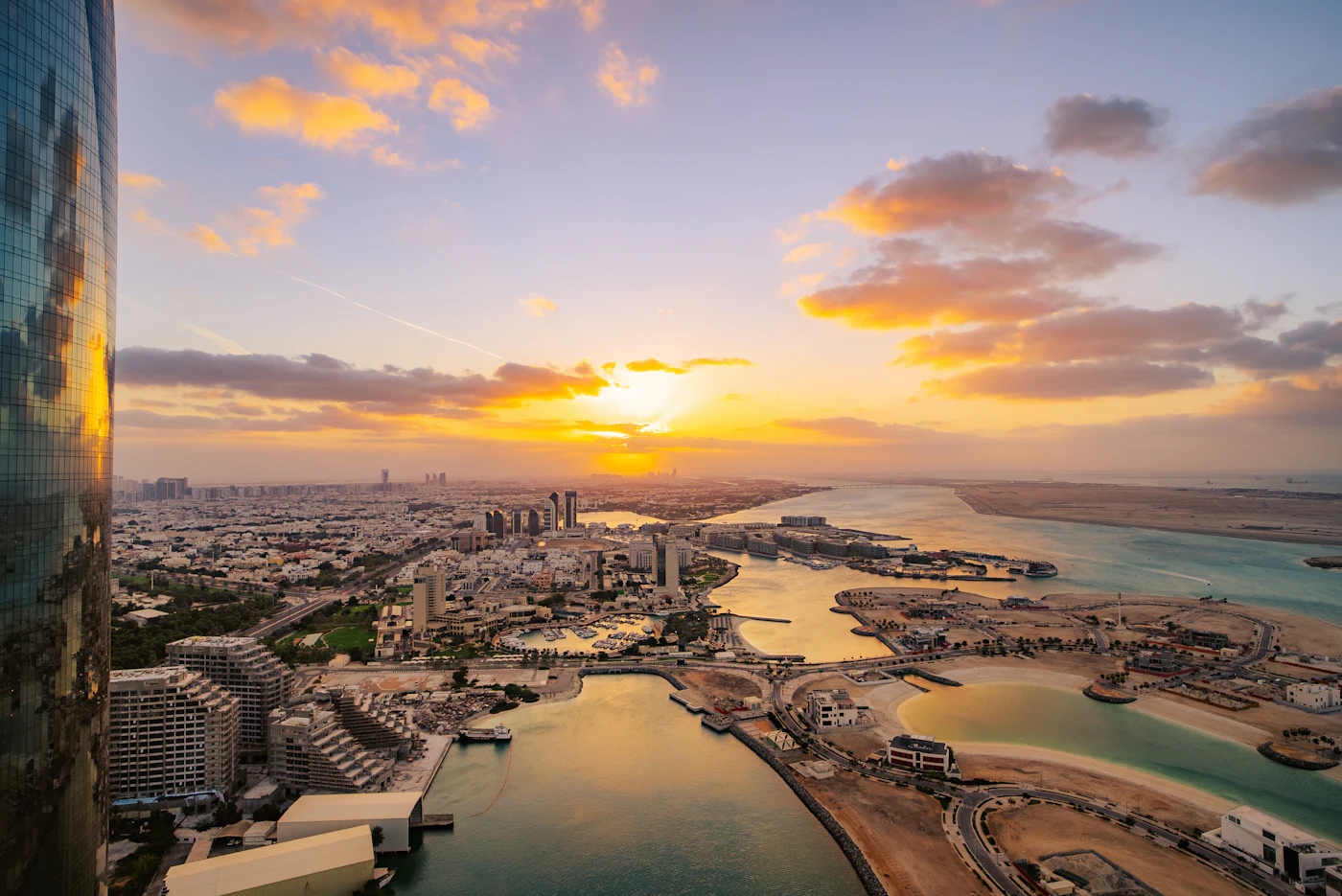 Aerial view of a coastal city and marina at sunset