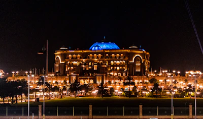 An ornate Arabian palace illuminated by warm evening lights.