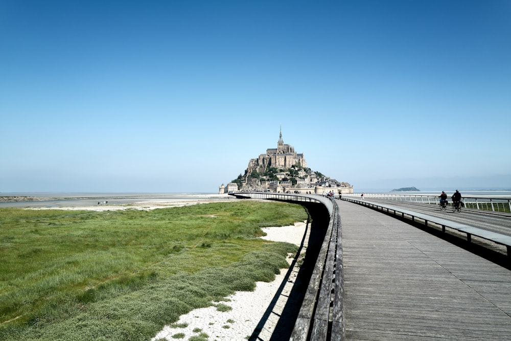 a long wooden walkway leading to a castle on top of a hill