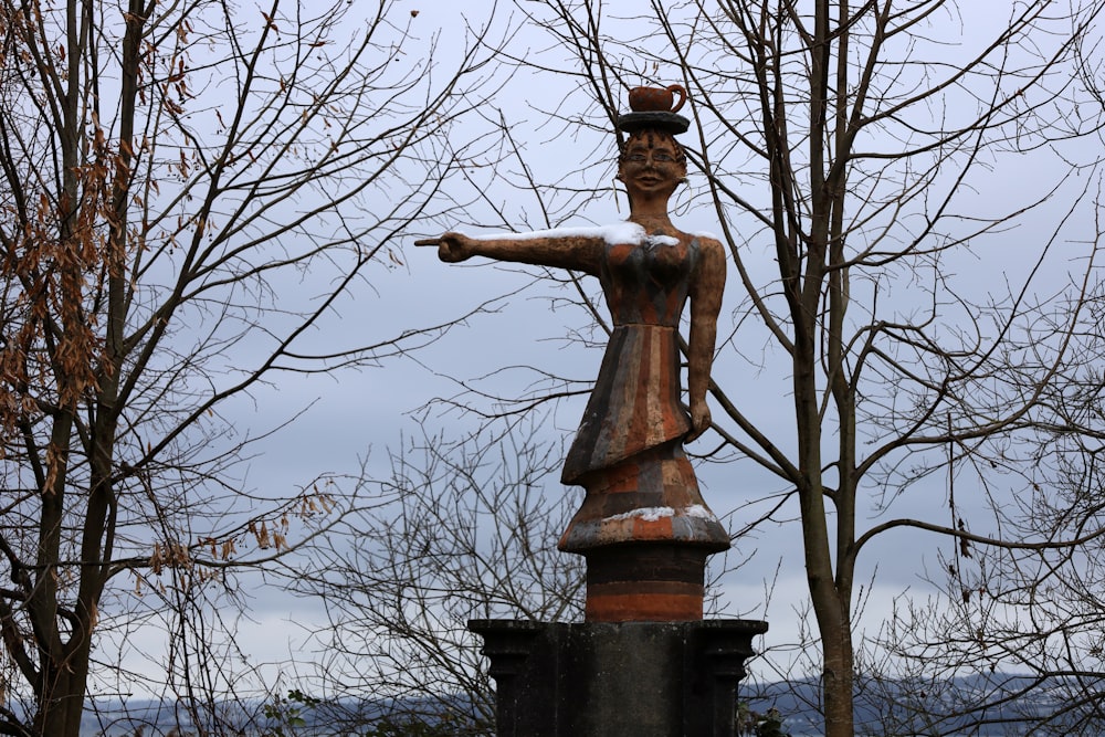 a statue of a woman with a hat on top of it
