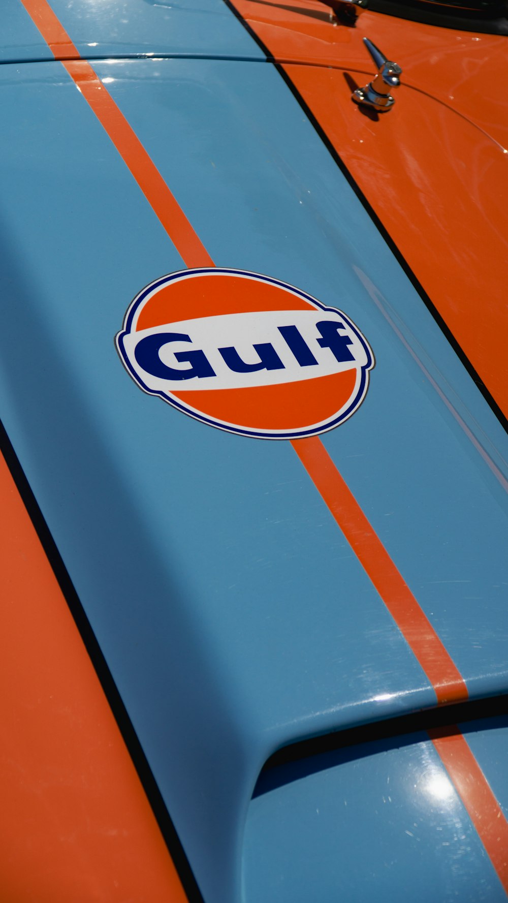 a close up of the hood of an orange and blue car
