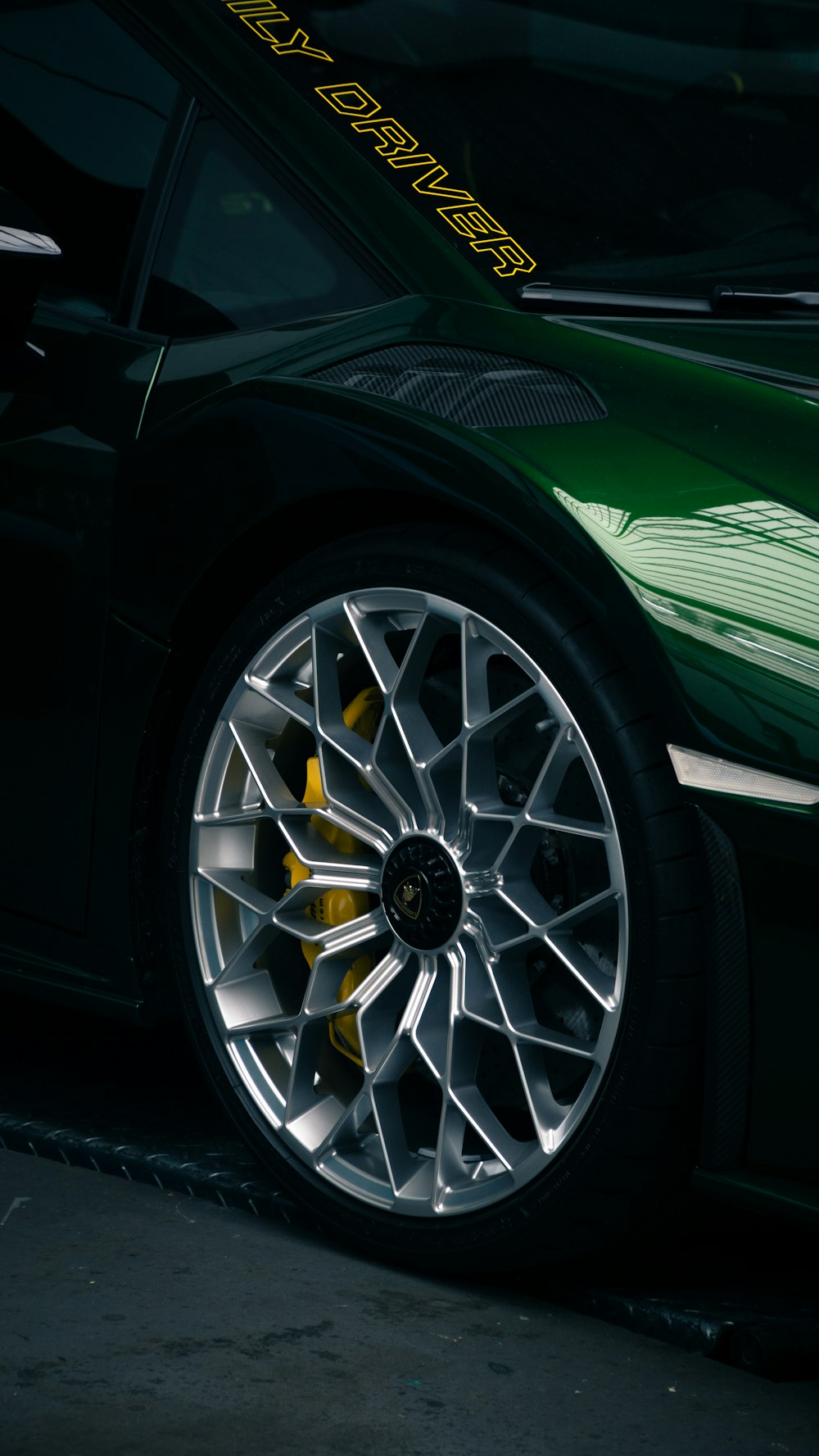 a green sports car parked in a garage