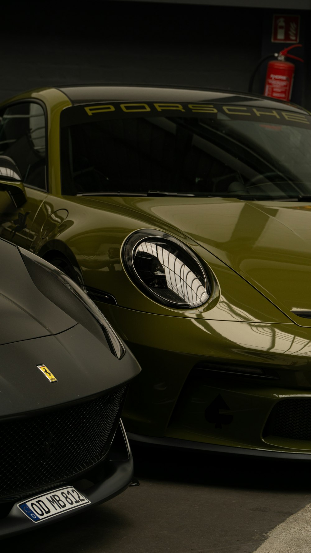 a green sports car parked next to a black sports car