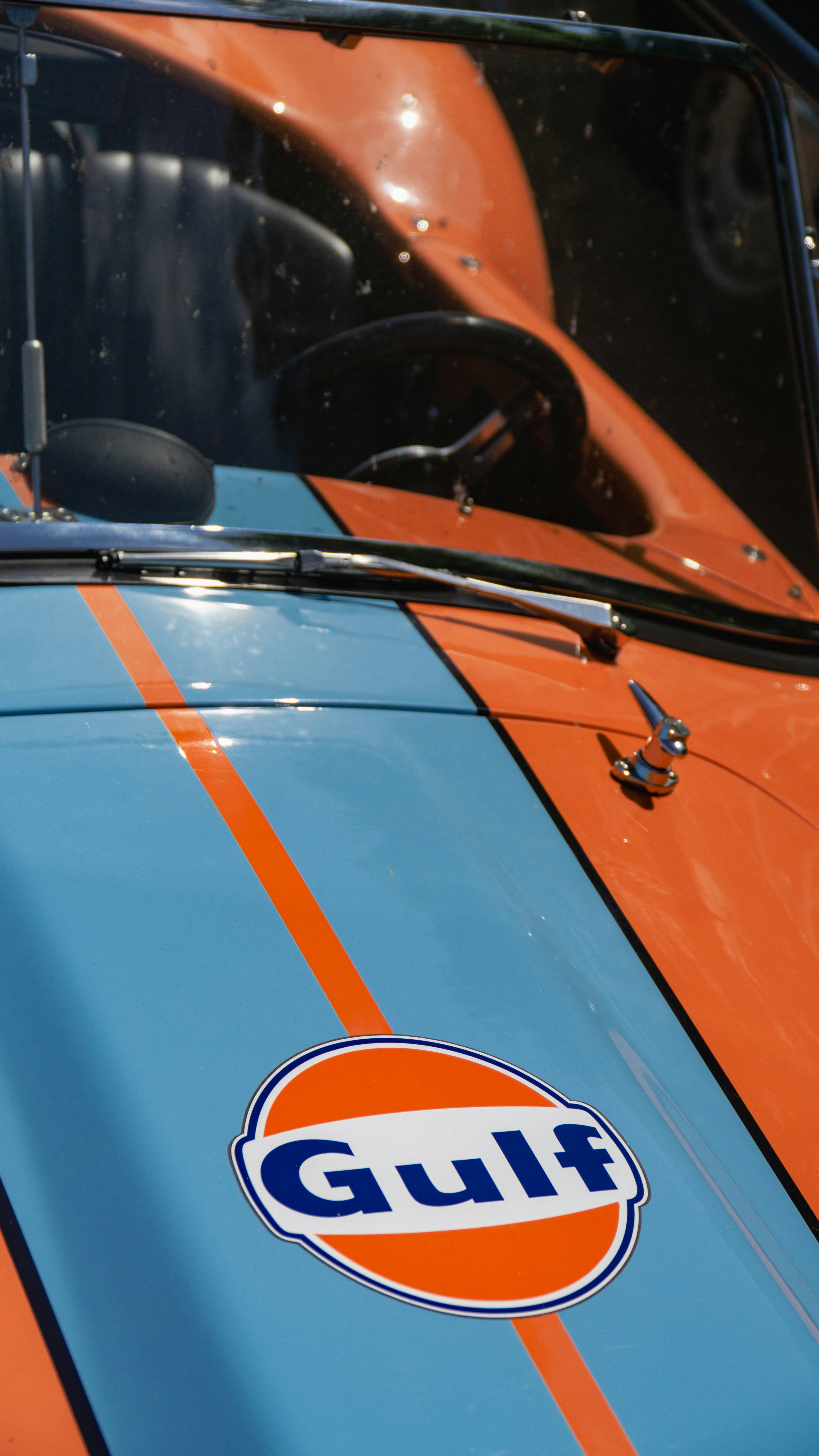 Un coche naranja y azul con la palabra Gulf en él