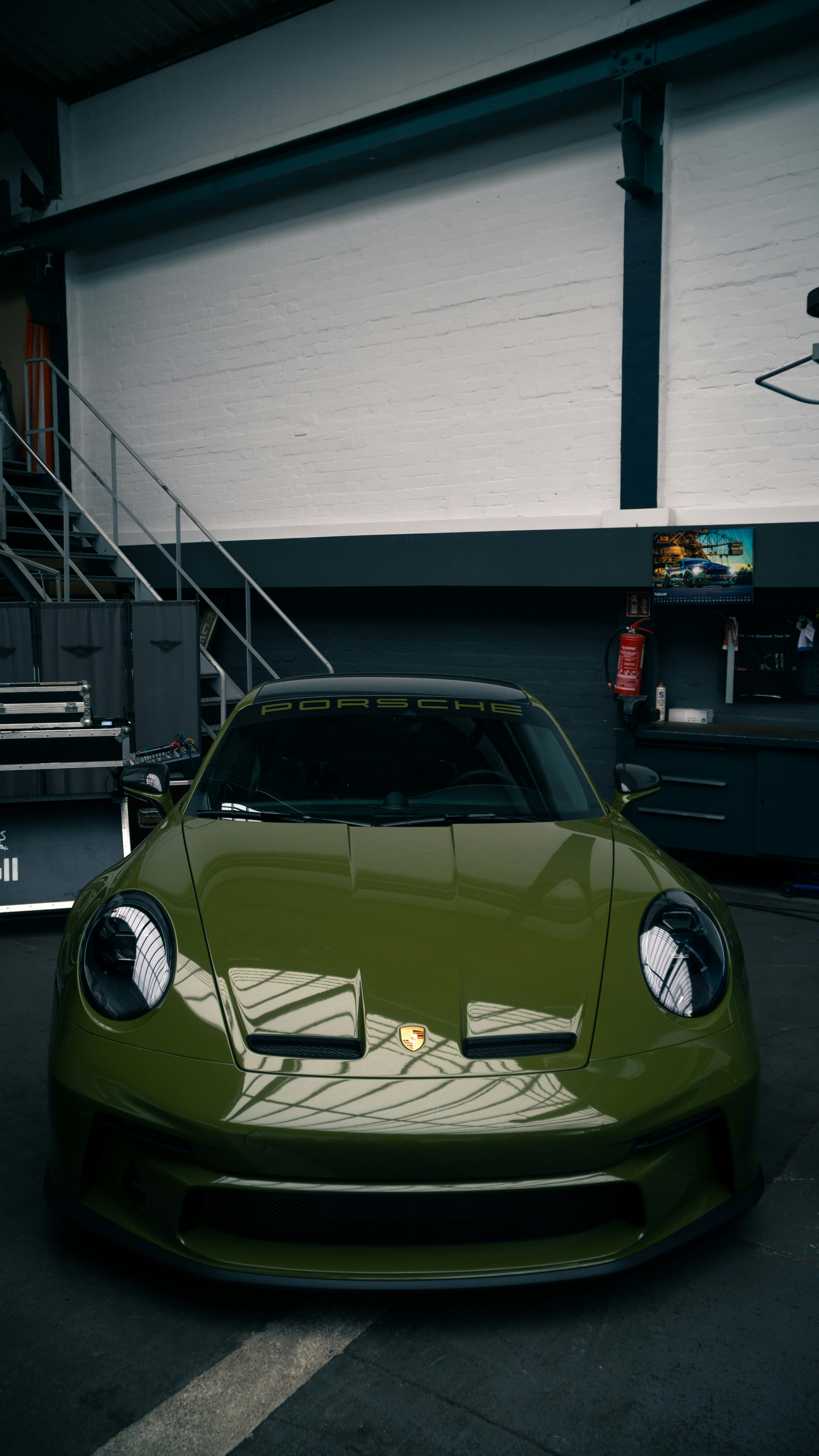 a green sports car parked in a garage