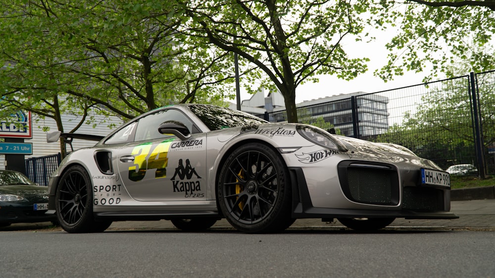 a silver sports car parked on the side of the road