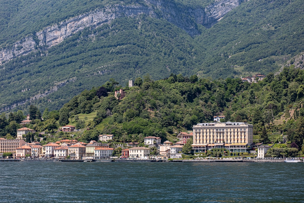 a large body of water next to a lush green hillside