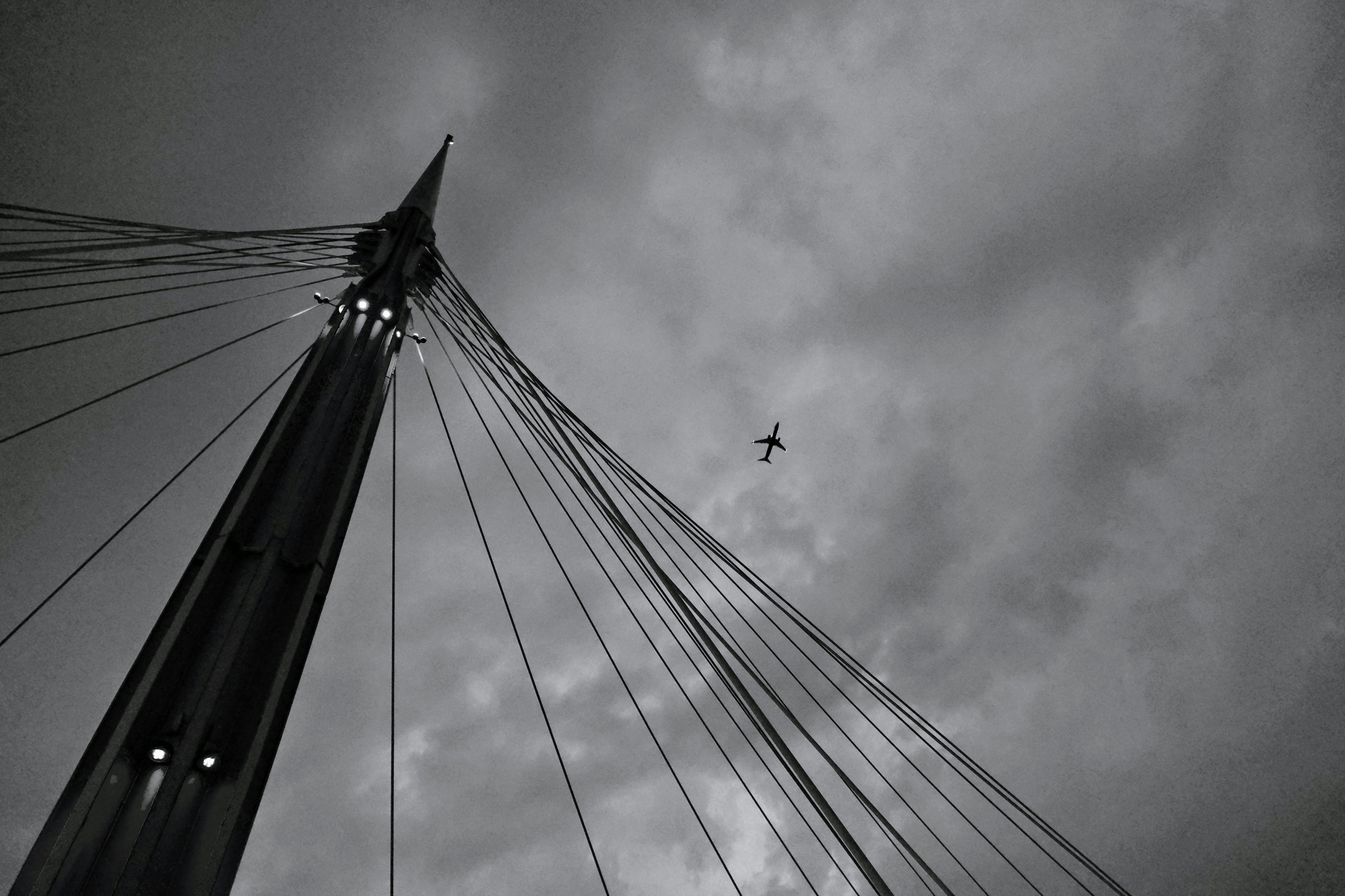 A black and white photo of a plane flying in the sky photo – Free Italy