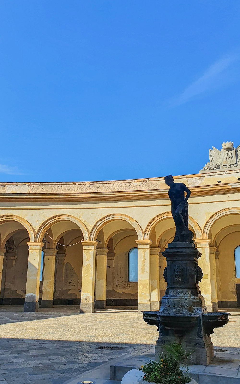 a statue of a man on a pedestal in a courtyard