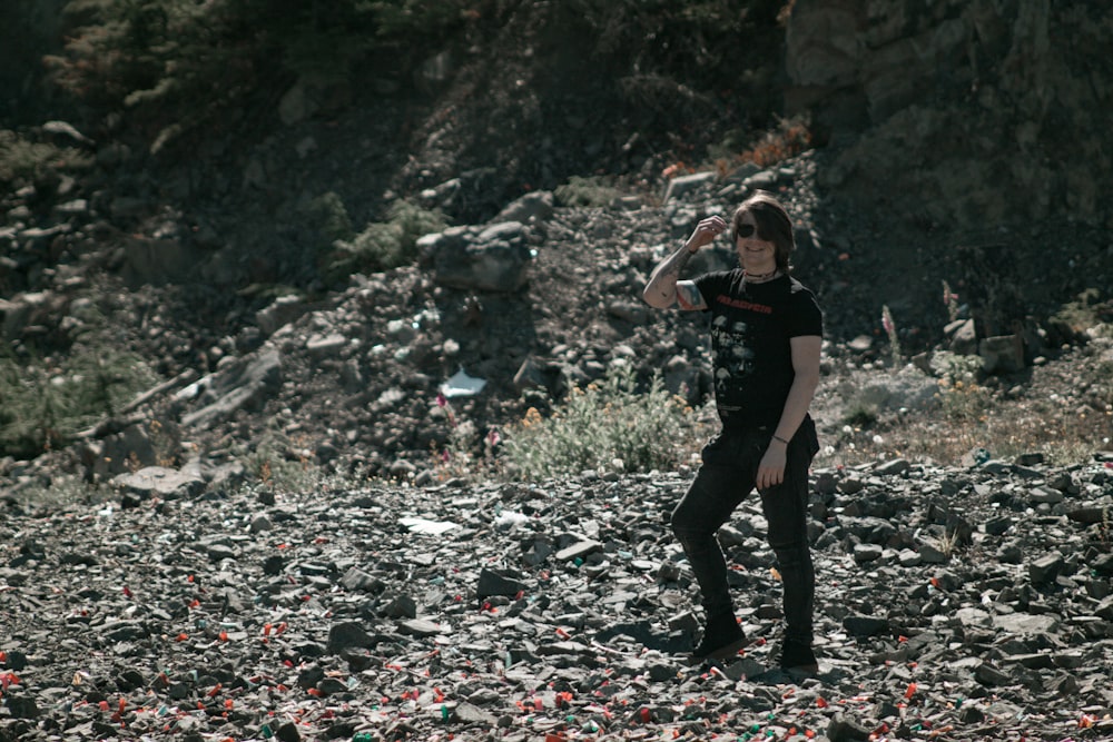 a man standing on a rocky hillside with a frisbee in his hand