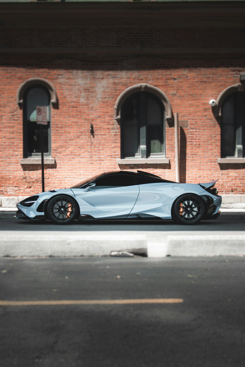 a blue sports car parked in front of a brick building