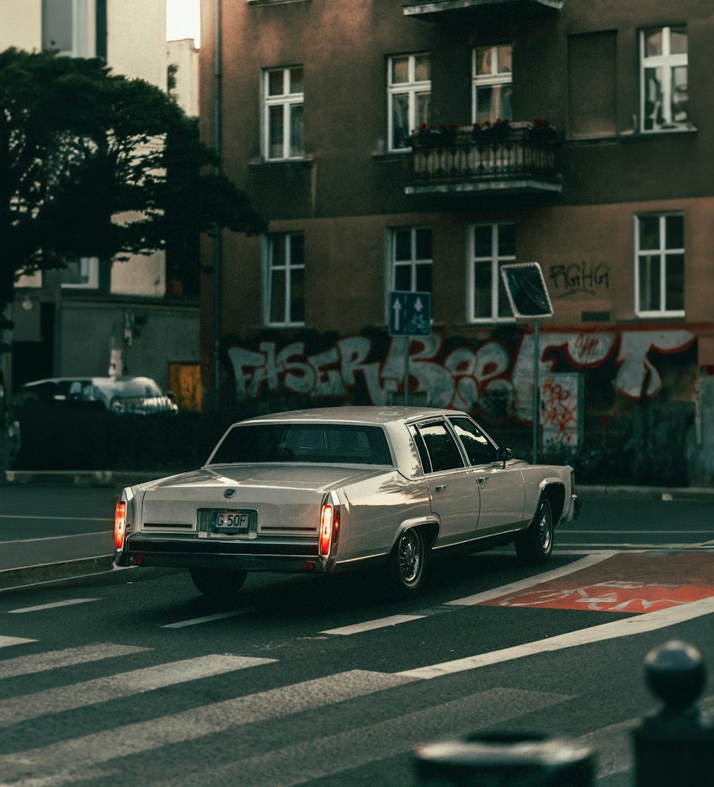 a car driving down a street next to a tall building