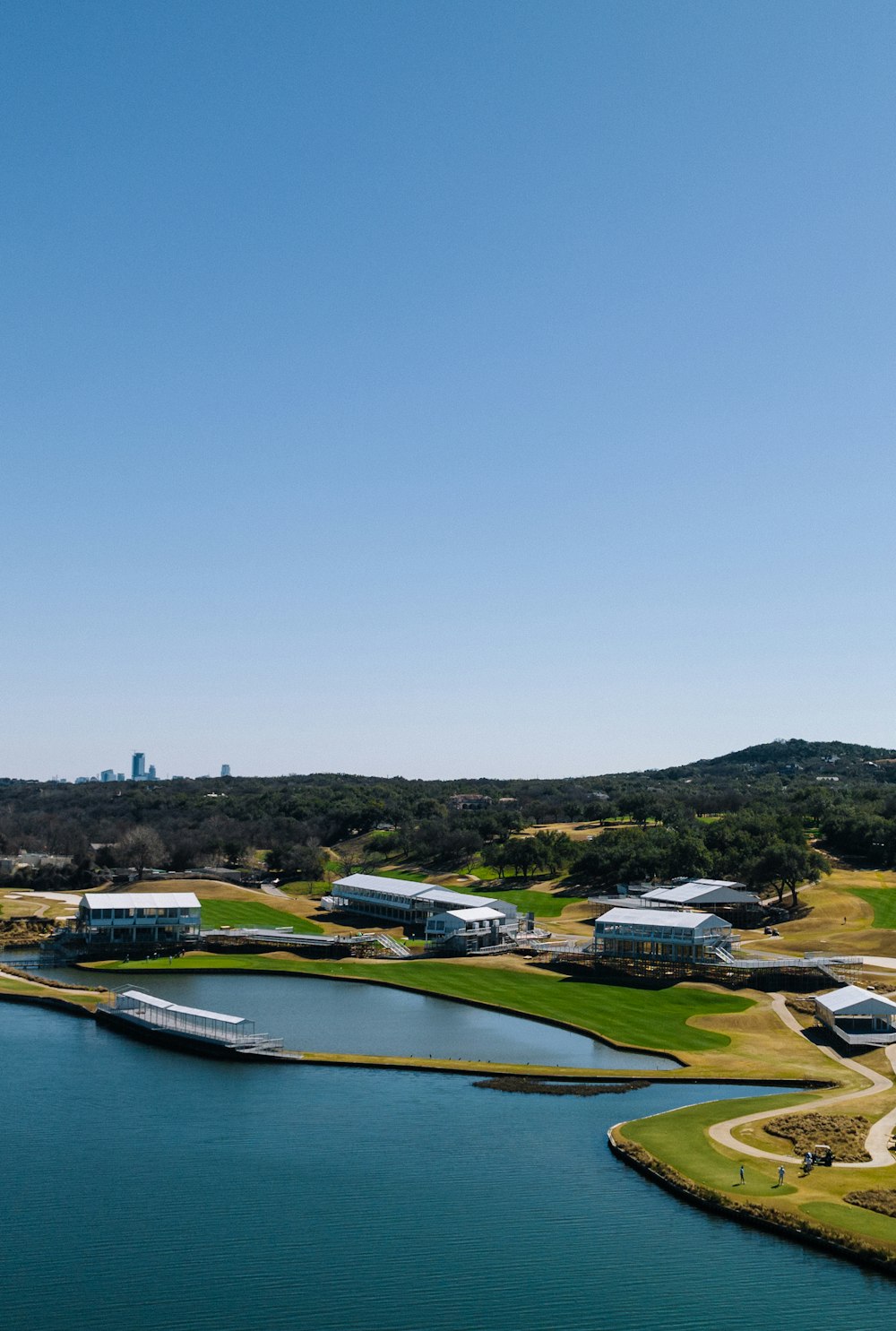 uma vista aérea de um campo de golfe com um lago em primeiro plano
