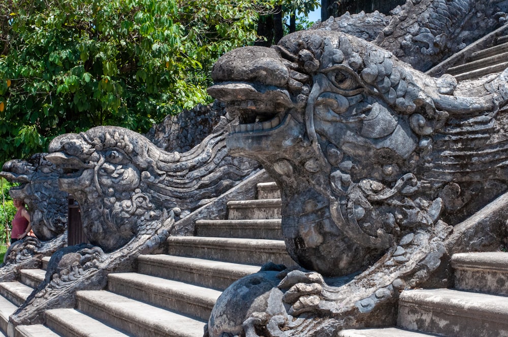 une statue d’un dragon assis au sommet d’un escalier