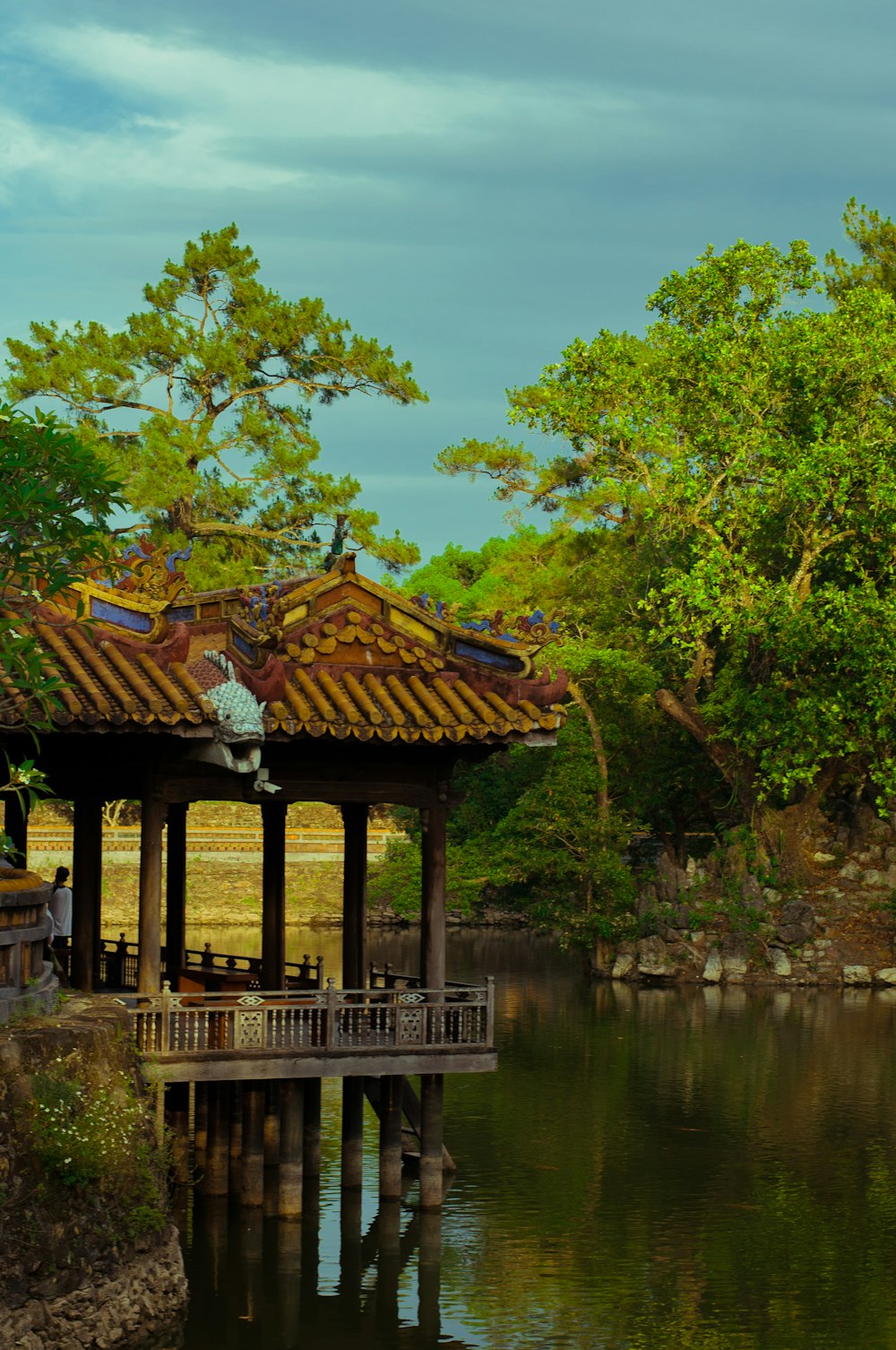 a gazebo in the middle of a lake surrounded by trees