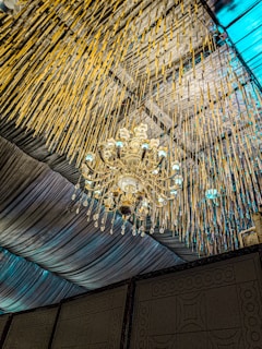 A minimalist blue background with a stylish chandelier hanging elegantly.