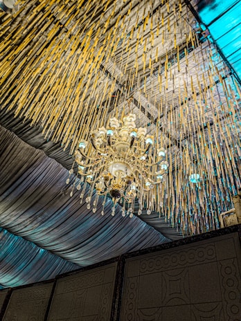 A minimalist blue background with a stylish chandelier hanging elegantly.