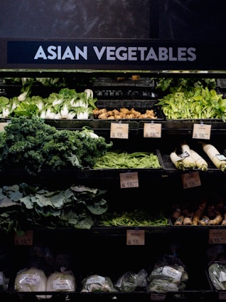 Assortment of fresh Asian vegetables neatly arranged in a store.
