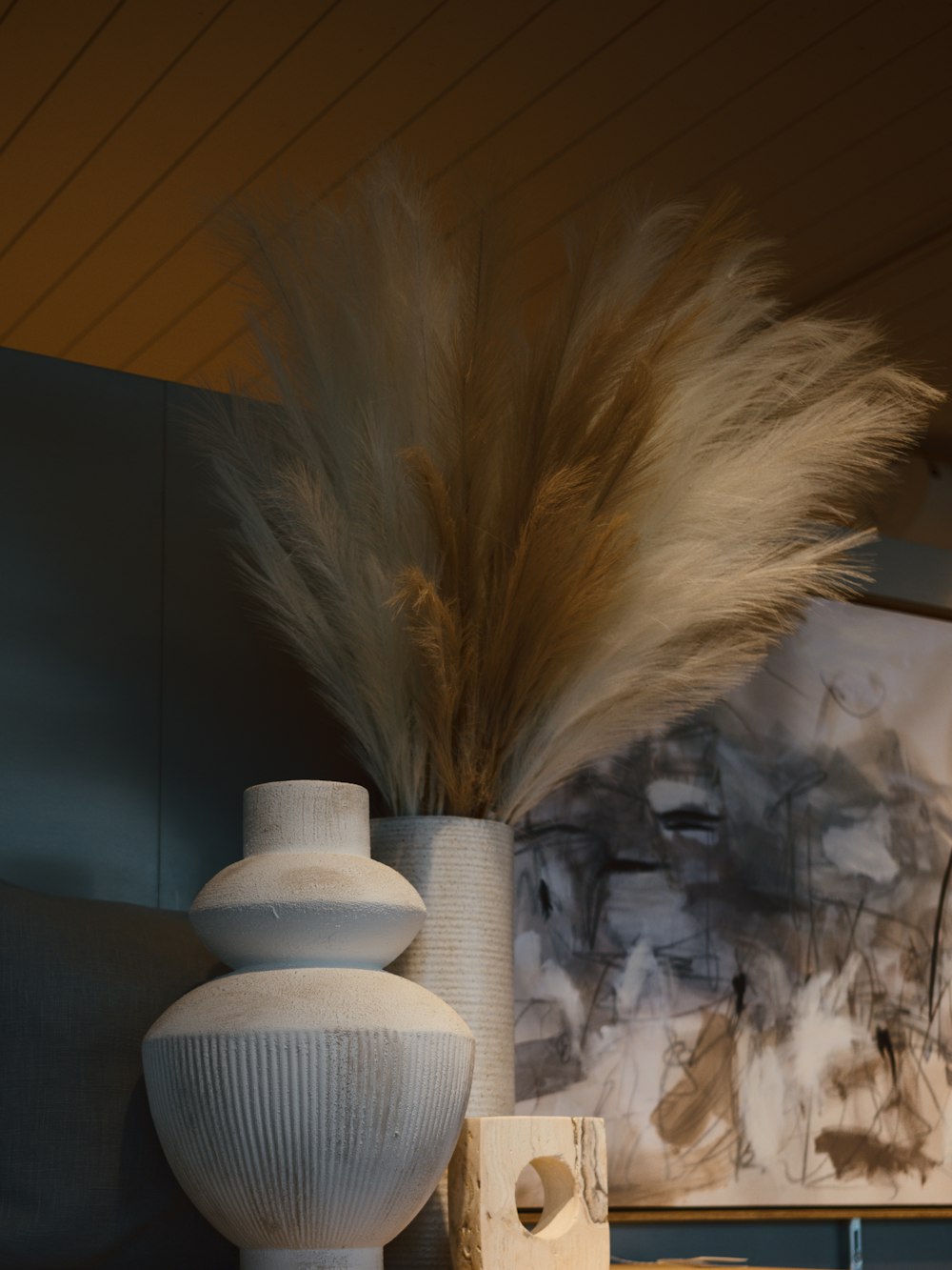 a white vase sitting on top of a wooden table