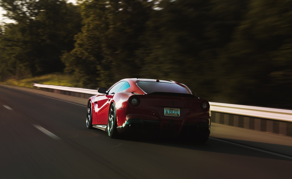 a red sports car driving down the road