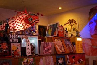 A candid portrait of Allen Schwartz surrounded by his colorful paintings and musical instruments.